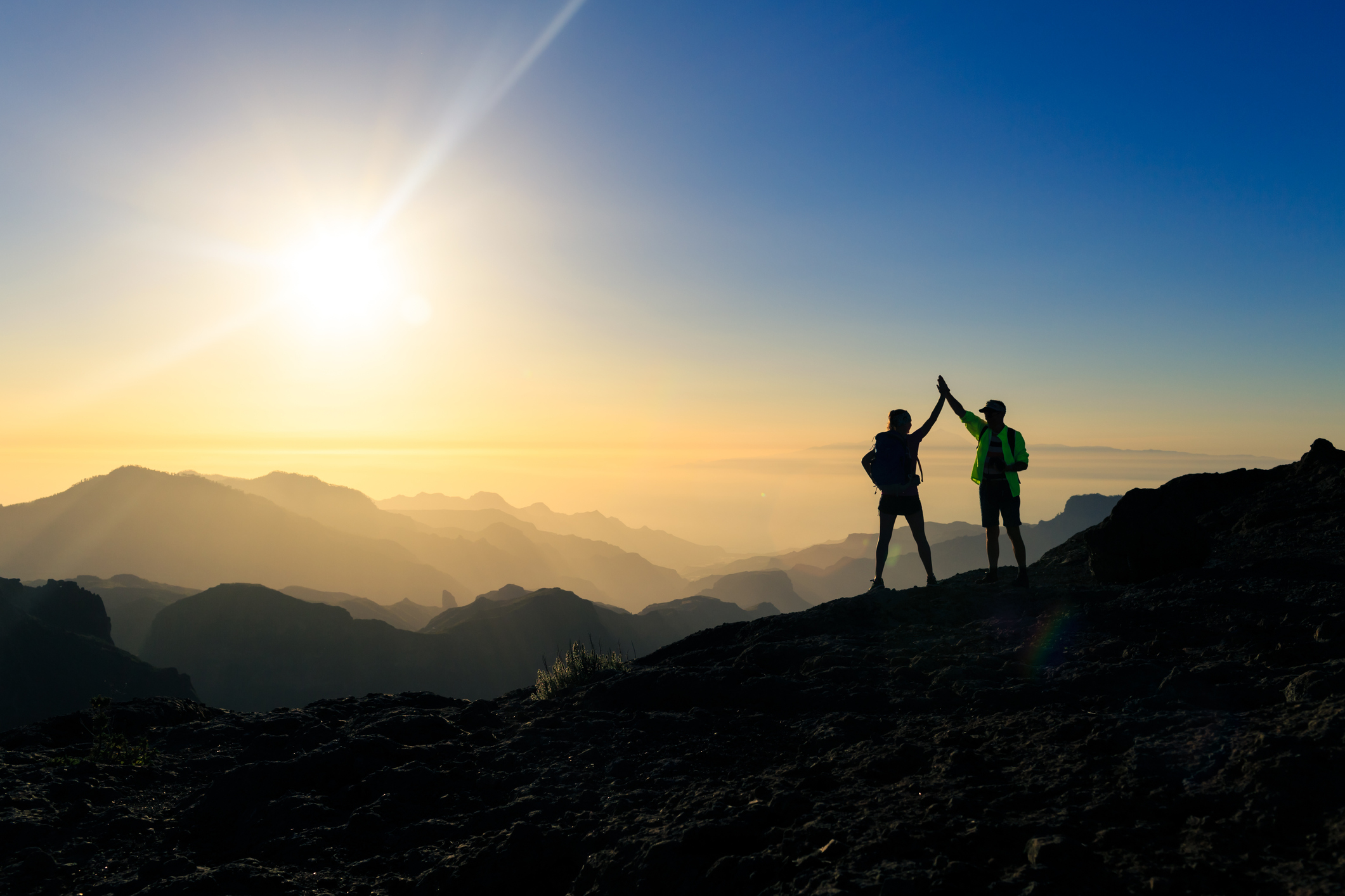 Couple hikers celebrating success concept in mountains